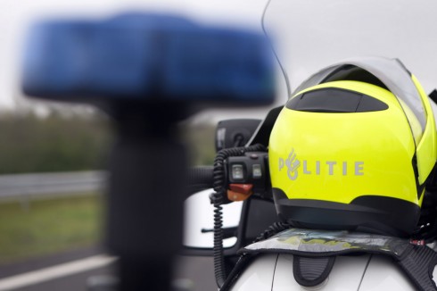050209 GRONINGEN - vrij - Politieagent in uniform op / bij de BMW motor