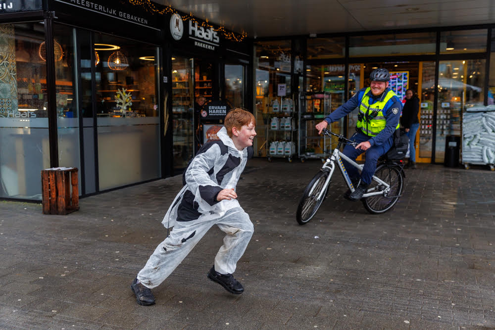 Jongeren in witte overalls op de vlucht voor politie en boa’s tijdens Hunted in Haren